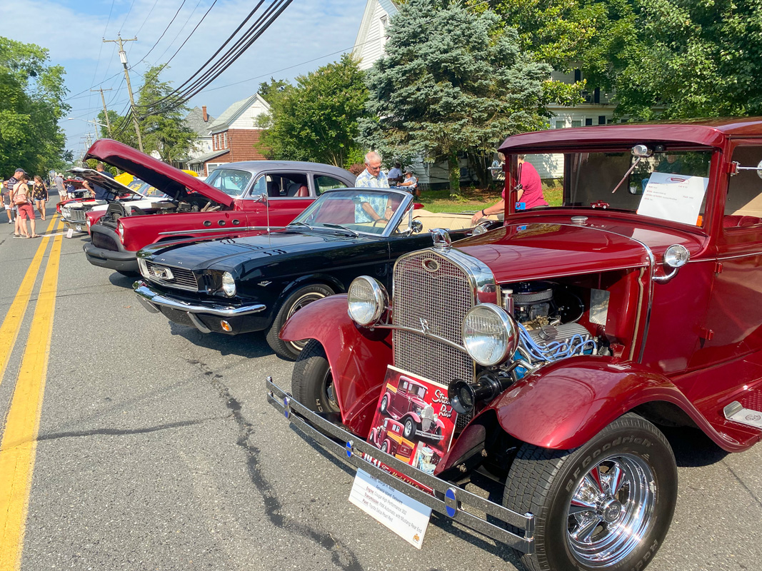 Multiple classic cars parked on the street for showing
